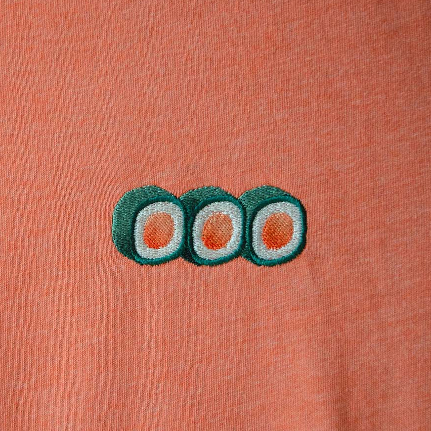 Embroidered sushi design on a peach-colored fabric